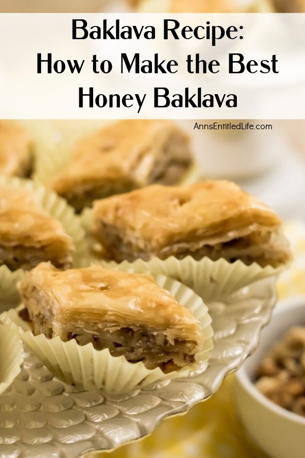 A close up view of diamond-shaped baklava in white paper holders on a clear pastry dish.