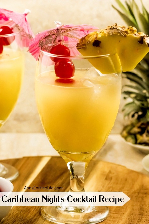close-up of a Caribbean Nights cocktail, garnished with pineapple and cherries and cocktail umbrella