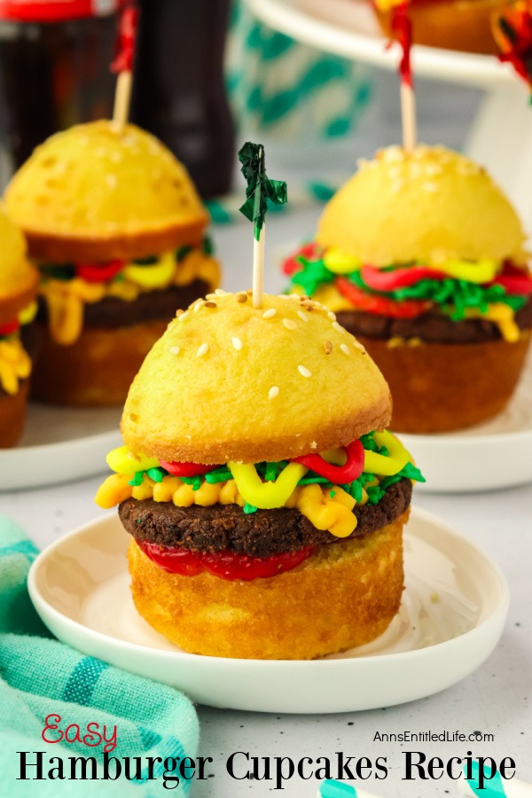 close-up of three cupcakes assembled to look like hamburgers sitting on white plates