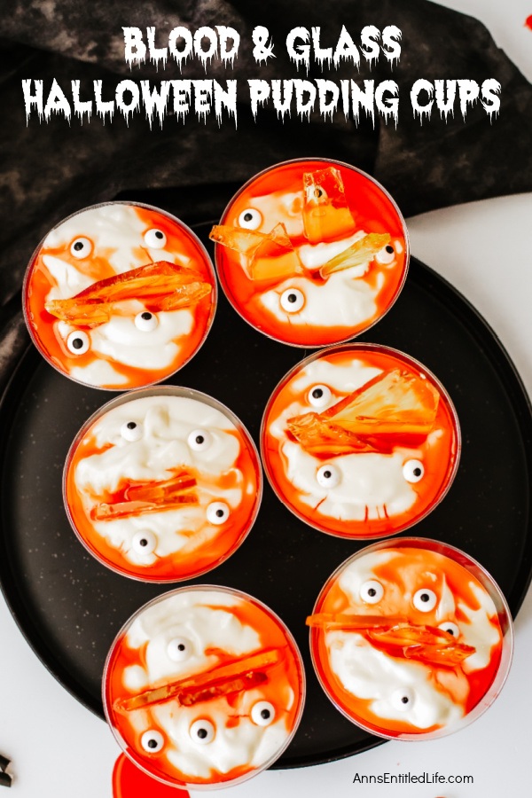 Overhead view of six homemade blood and glass pudding cups on a black serving dish