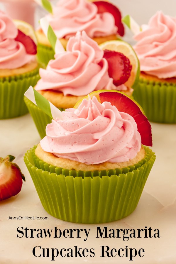 a close-up of a decorated strawberry margarita cupcake, several more cupcakes are in the background