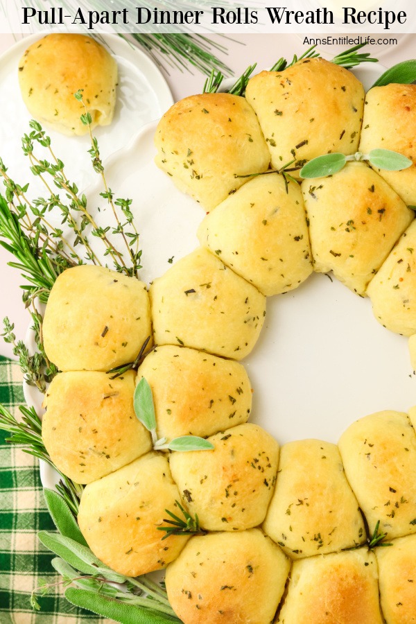 Overhead, closeup view of half a rosemary wreath roll, there is one roll detached from the wreath