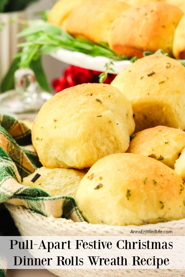 a closeup of rosemary dinner rolls in a white basket, the rest of the dinner wreath roll is in the upper right on a white serving plate