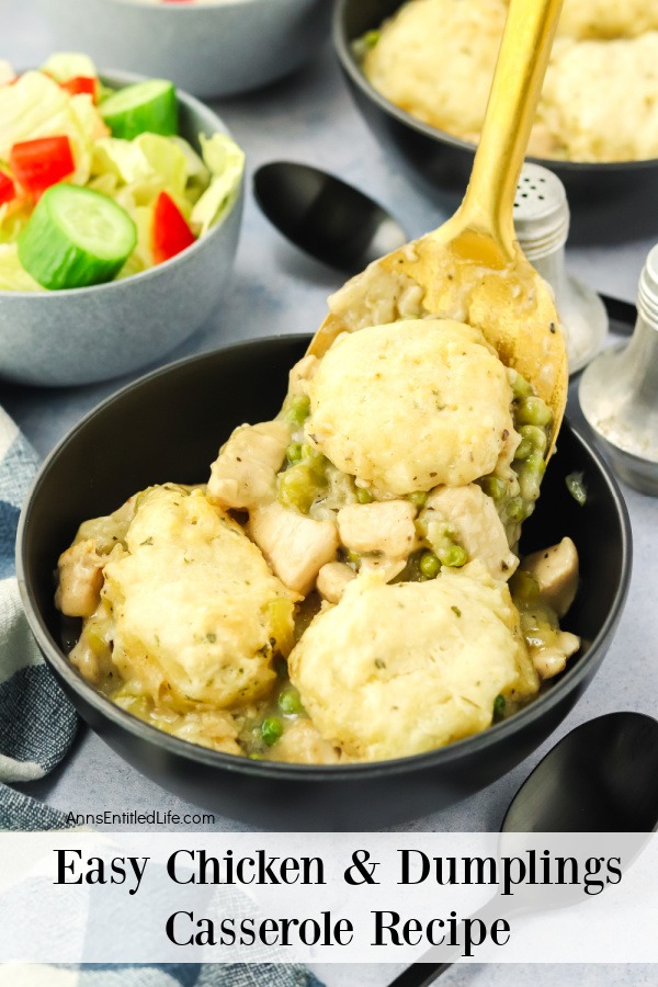 Chicken and dumplings being spooned into a black servings bowl. There is a salad bowl to the left.