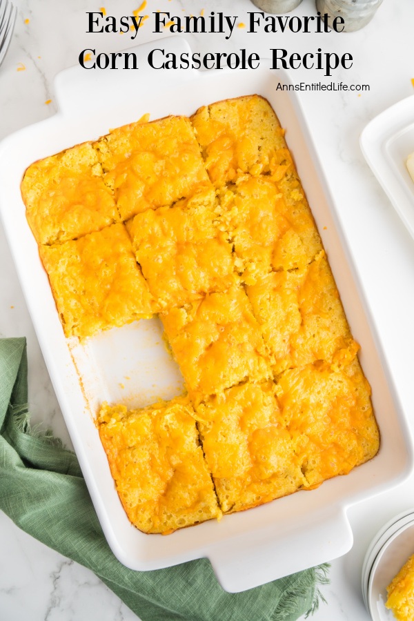 Overhead view of a corn casserole in a white dish with a piece removed