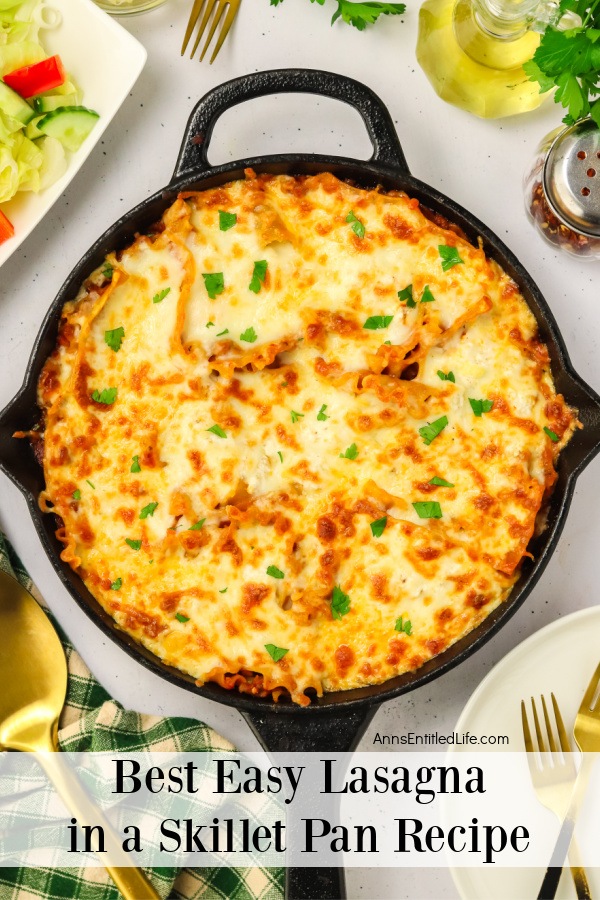 Overhead view of a pan of skillet lasagna. There is a wooden spoon on the lower left, and a container of red pepper flakes in the upper right